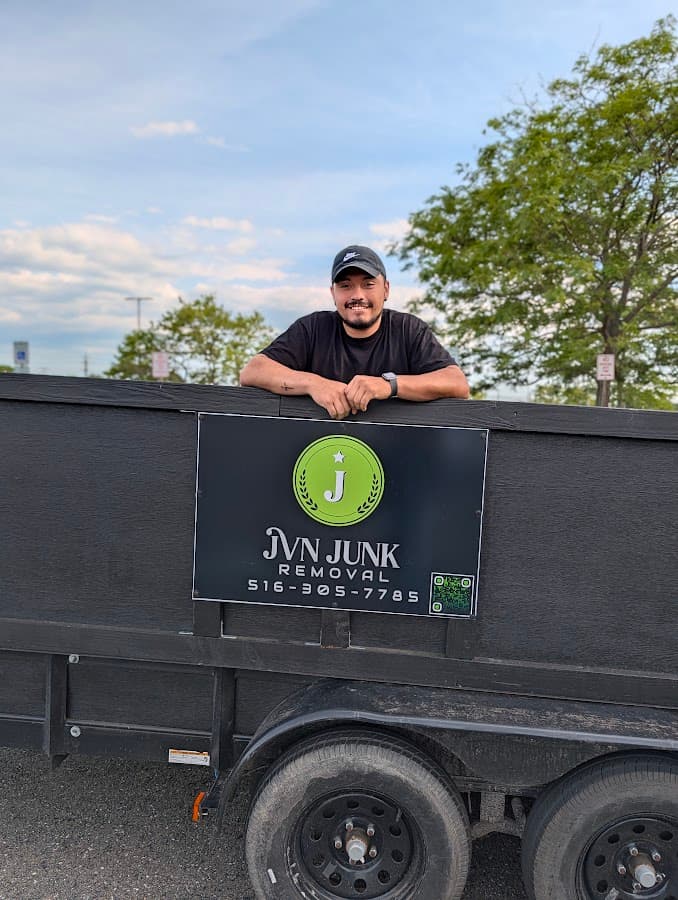 JVN Junk Removal professional standing behind a work trailer