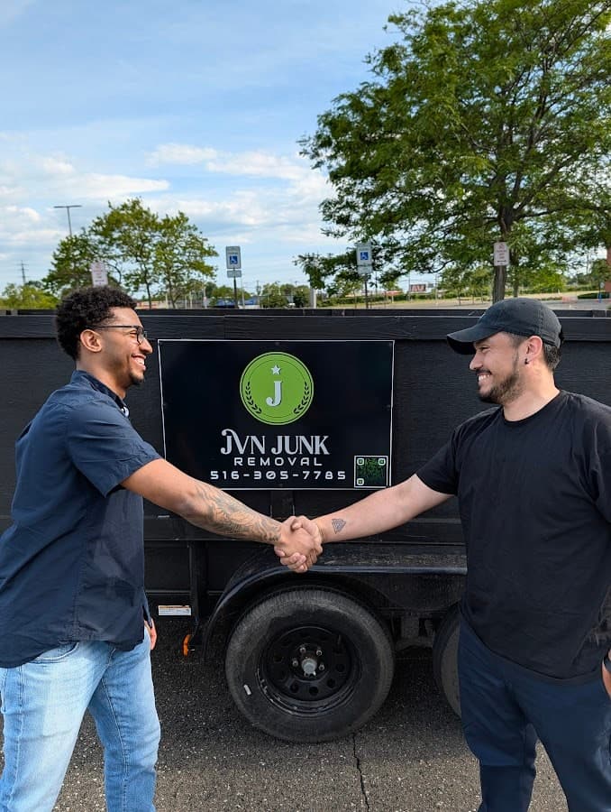 Corely team member and JVN Junk Removal professional shaking hands beside the JVN truck